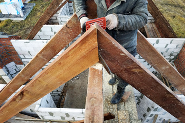Workers cut the rafters on the roof of the chainsaw house