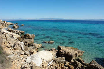 View of the stony coast and the turquoise sea in Greece.