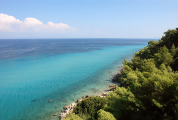Panoramic view from the hill on the coast with the crystal clear sea of turquoise color in Greece.