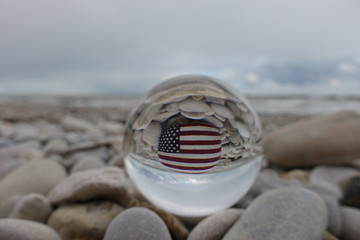 United States of America flag painted on a stone after a crystal ball on the beach