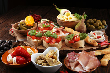 Italian antipasti wine snacks set. Cheese variety, Mediterranean olives, pickles, Prosciutto di Parma, tomatoes, artichokes