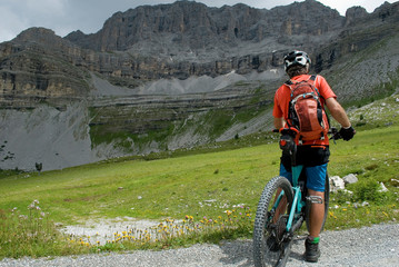 Fototapeta premium man with an electric bike, e-bike, ebike, mtb, rock, mountain, Dolomites, Madonna di Campiglio, summer, sport, adventure, alps, travel, Trentino Alto Adige, Italy