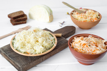 Sauerkraut in plates on the kitchen table. Fermented cabbage. 
