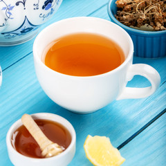 Cup of Linden Tea, Dried Linden Flowers in Cup with honey and lemon on wooden background.