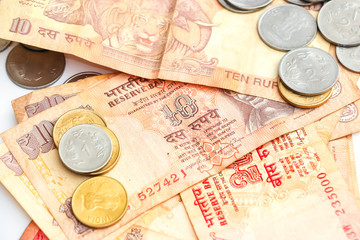 Close up view of indian banknotes and coins on white background.