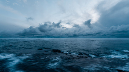 Seascape of mediterranea sea after storm with light through the clouds in winter blue hour during puglia travel at sunset