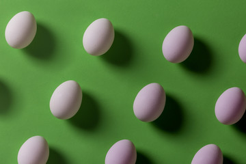 Pattern of fragile white eggs on green background