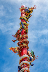 The pillar of dragon in Chinese temple. Traditional Dragon column with colorful decoration against blue sky, Thailand.