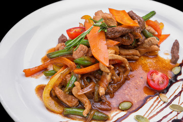 Slices of fried veal with vegetables on a white plate