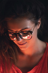 Young woman with reflection of glowing light balls in her eye glasses