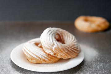 sprinkled with powdered sugar sweet tasty donuts on a white plate