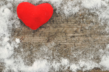 Valentine's day and Love composition with red plush heart on wooden background in snow. Healthy lifestyle concept.