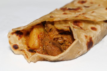 Close-up of a lamb roti roll - an Indian bread with lamb curry as a filling, a popular Indian dish...