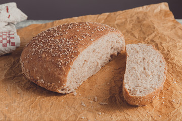 Freshly baked loaf of wholemeal bread with bran on baking paper