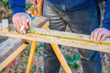 Handyman measuring materail for construction project.