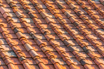 Fototapeta premium Ceramic orange clay tiles on the roof of a building.
