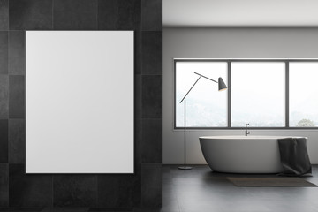 Fototapeta na wymiar Gray tile bathroom with tub and poster