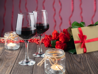 Romantic cozy evening with wine, flowers, candles and present
