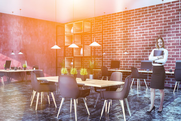 Red and brick office corner with table, woman