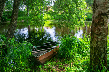 Obraz premium Boat on the river near the shore. Sunny day, flat river in summer.