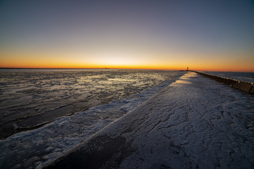 dramatic red sunset over the frozen sea on the beach