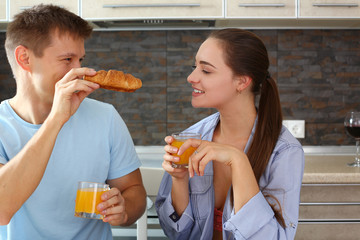 man and woman in the kitchen eat breakfast juice