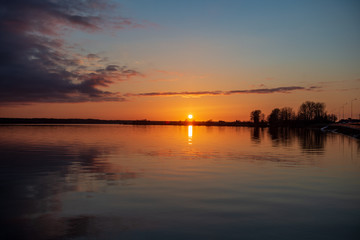 Fototapeta na wymiar beautiful. red sunset over the sea, lake with clear sky