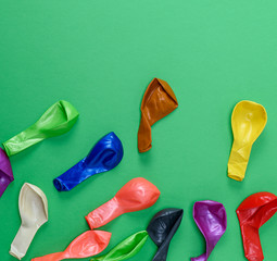 colorful deflated balloons on a green background