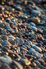 abstract details of rocky beach pebbles in sunset by the sea