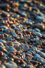 Obraz premium abstract details of rocky beach pebbles in sunset by the sea