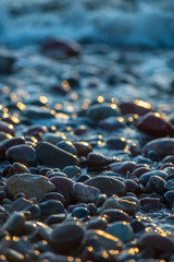 Obraz premium abstract details of rocky beach pebbles in sunset by the sea
