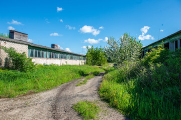 country gravel road with old and broken asphalt