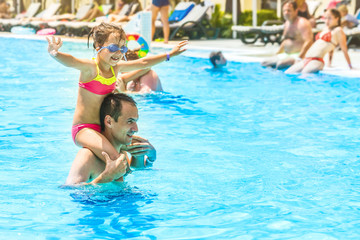 Naklejka premium Little girl and happy dad having fun together in outdoors swimming pool
