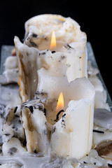 Old soiled big candles on a wooden black table. An old method of lighting rooms.