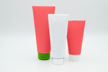 Three different size cosmetic or medicine tubes with colourful blank coverings isolated on a white background