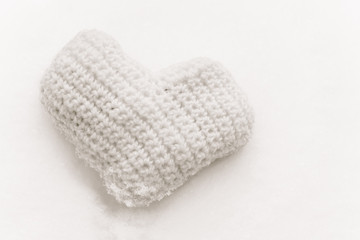 Pink knitted heart on the snow