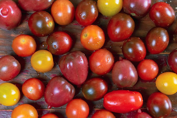 Closeup of variety of cherry tomatoes on rustic wood background