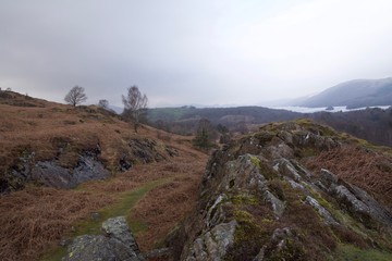 Moor valley with misty mountains and lake in distance