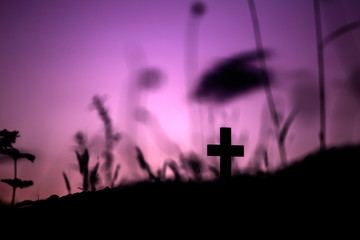 Cross in silhouette on a hill with light sunset background. christian concept.