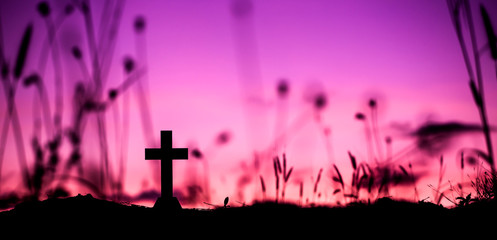 Cross of Jesus in silhouette on a hill with light sunset background. christian concept.