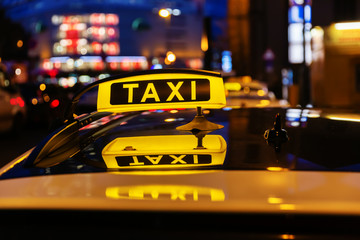 taxi sign on the roof of a taxi at night