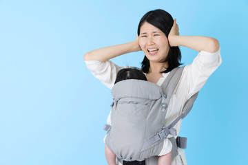portrait of young asian mother and baby on blue background