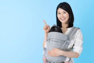 portrait of young asian mother and baby on blue background