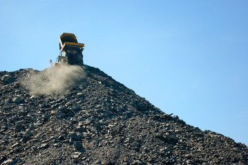 construction truck transports rocks dump on blue sky