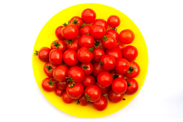 many cherry tomatoes plate red background top view