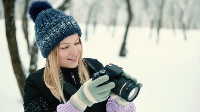  young girl photographer in the winter snowy park photographs nature.