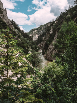 View of river passing through mountain against cloudy sky