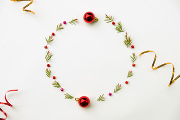 Christmas and Happy new year composition. Wreath from green fir leaf , red ball and ribbon on white background. Flat lay, top view, copy space use for template and greeting card.