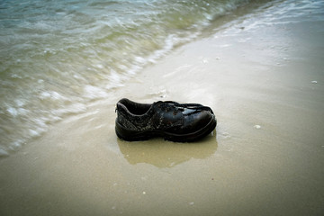 shoes garbage the beach / sea water pollution with old shoes on sand in the beach save the earth concept