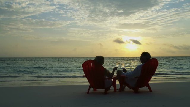 Healthy senior Caucasian couple drinking wine Caribbean paradise 